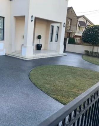 A finished residential concrete driveway outside a home