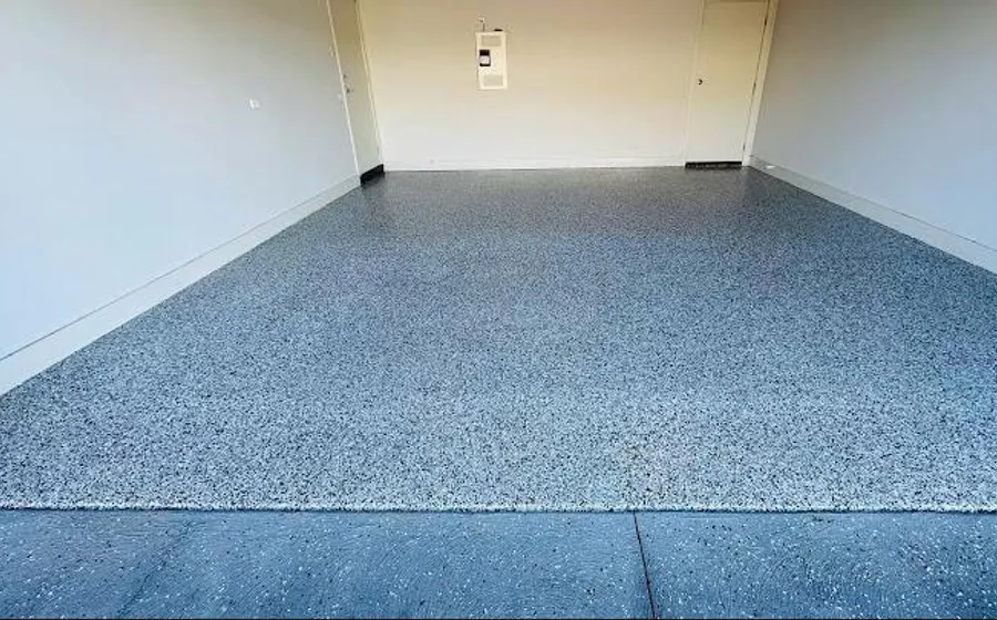 A garage floor finished in grey flake epoxy